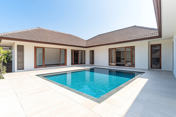 Fototapeta premium Modern villa with a swimming pool surrounded by clear skies during daytime