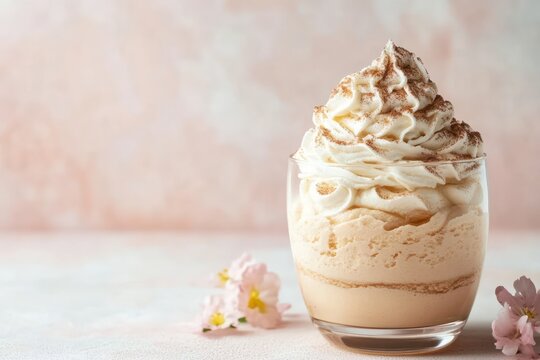 Yummy creamy fluffy coffee Mocha Mousse dessert in a glass cup with sakura flowers decoration on a soft light pink and beige background copy space