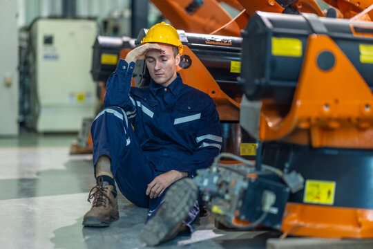 Stressed Factory Worker Resting on the Floor