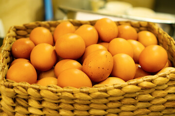 A pile of eggs is placed in a basket made of woven water hyacinth.