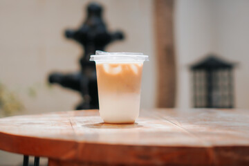 A refreshing glass of iced coffee sits on a wooden table, perfect for a sunny day. The image captures the drink's cool, refreshing appeal, perfect for cafes, food blogs, and lifestyle content.