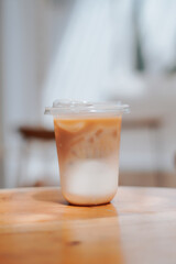 A refreshing glass of iced coffee sits on a wooden table, perfect for a sunny day. The image captures the drink's cool, refreshing appeal, perfect for cafes, food blogs, and lifestyle content.
