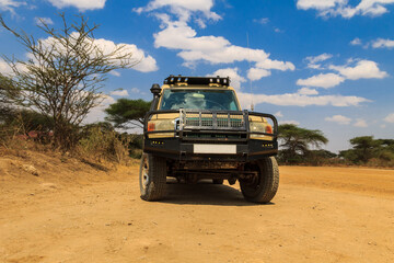 Obraz premium SUV car parked in Serengeti national park, Tanzania