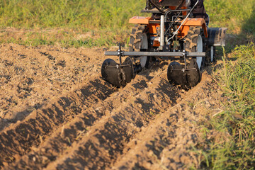 Mini Tractor with attachments to make the furrows in garden.