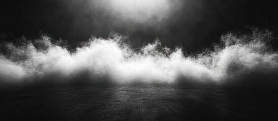 Dramatic, moody black and white image of a white fog or smoke cloud against a dark background.