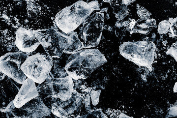 Ice cubes, crushed on a black background.