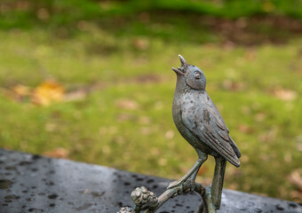 Singender Vogel auf einem Grabstein Friedhof in Essen