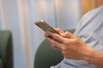 close up Businessman sitting at office table using mobile phone while online working at home office, business casual, telecommuting, working from home,