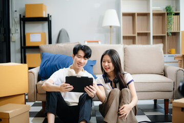 Young couple organizing belongings in a cozy home with boxes and luggage. Perfect for themes of moving