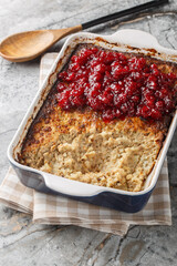 Finnish casserole Maksalaatikko made of Rice and liver with Cranberry sauce closeup on the baking dish on the table. Vertical