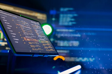 Programmer manually working with program code on a computer at night in a data center and...
