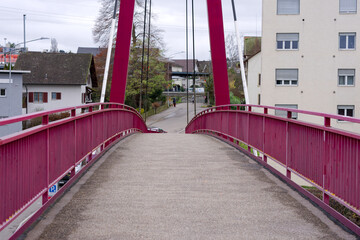 Obraz premium Close-up of red metal suspension footbridge village of Rümlang on an autumn day. Photo taken December 8th, 2024, Zurich Rümlang, Switzerland.
