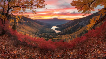 Fototapete Vibrant autumn leaves frame a stunning mountainous landscape as the sun sets over the tranquil valley and river creating a picturesque view © IQRA
