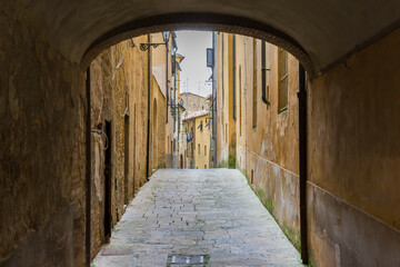 Arch over a narrow old street in historic city Volterra, Italy