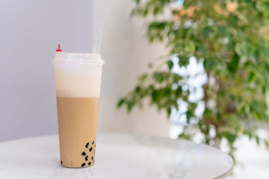 Close-up of a cappuccino bubble coffee with tapioca pearls on a table
