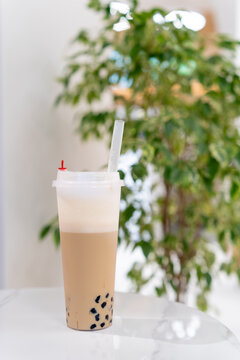 Close-up of a cappuccino bubble coffee with tapioca pearls on a table