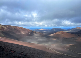 volcanic landscape with a volcano crater in the foreground and the ocean in the background on a...