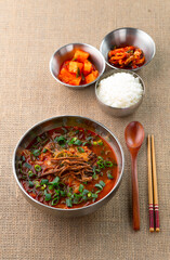 뜨끈한 육개장과 밥, 깍두기, 김치로 구성된 한식 한상이 정갈하게 담겨 있습니다. 깊고 얼큰한 육개장은 속을 따뜻하게 달래주며 한국의 대표적인 보양식 중 하나입니다.