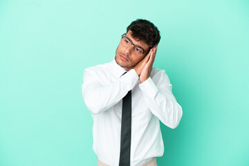 Business caucasian man isolated on blue background making sleep gesture in dorable expression