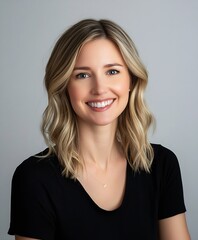 Obraz premium Professional Portrait of Smiling Woman with Blonde Hair in Black Attire Against Gray Background : Generative AI