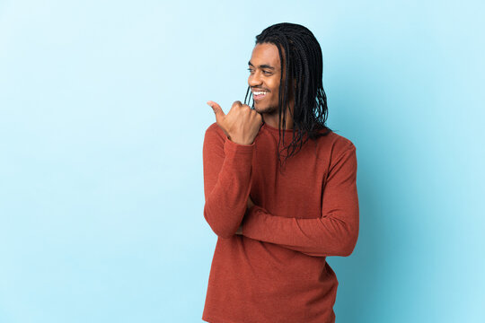 Delivery African American man with braids isolated on white background pointing to the side to present a product