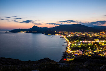Fototapeta premium Beautiful view of the night embankment of the city of Sudak after sunset. South coast of the Crimean peninsula. Russia