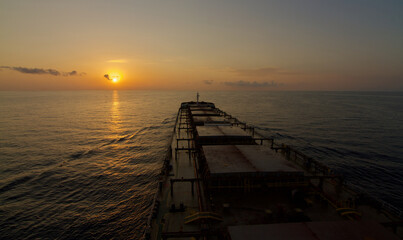 A merchant ship underway at sea during Sun rise