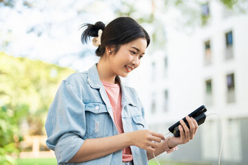 Woman holding phone and charger, power bank and smartphone in girl's hand, power bank charging...