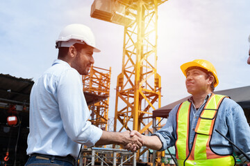Group of male engineer construction putting their hands together at construction site. Teamwork of male construction builder at construction site. Unity and teamwork concept