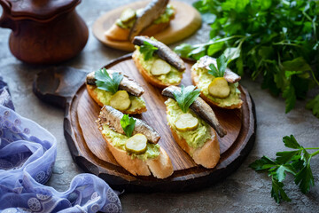 Sandwiches with avocado, fish and cucumber on a wooden plate on a wooden table for breakfast. delicious sandwiches. Close-up
