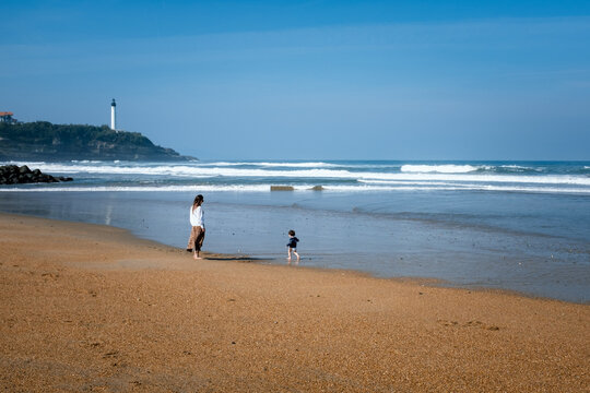 Mother and son taking a walk on Anglet Beach, France.