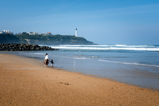 Mother and son taking a walk on Anglet Beach, France.