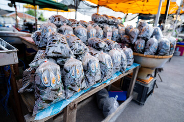 Cooked mussels packed in plastic bags for sale in the market of Thailand.