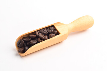 Coffee beans on wooden scoop isolated on white background