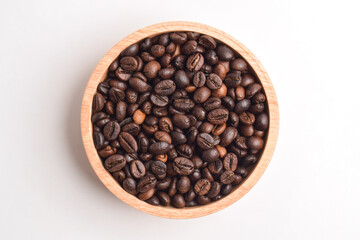 Roasted coffee bean in wooden bowl isolated on white background. Top view. Flat lay.