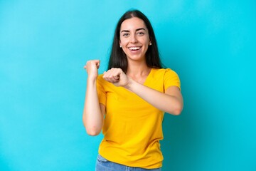 Fototapeta premium Young caucasian woman isolated on blue background pointing to the side to present a product