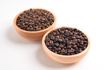 Roasted coffee bean in wooden bowl isolated on white background.