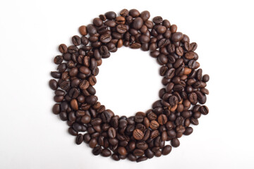 Roasted coffee beans with a circle Frame in the center on a white background. Top view with copy space for your text