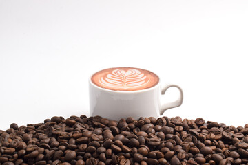 Cup of coffee placed on rich coffee beans isolated on white background