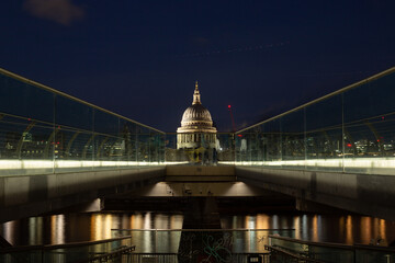 Night view of London's iconic Millennium Bridge leading to Saint Paul's Cathedral across the Thames river