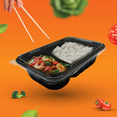 Picture of food in a black plastic tray with 2 compartments
placed in an orange background and contains various vegetable ingredients
There are both red and green vegetables, very delicious to eat.