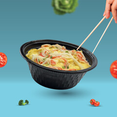 Picture of baked bacon with cheese in a black plastic cup.
Set in a blue background and with various vegetable elements.
There are both red and green vegetables, very delicious to eat.