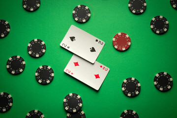 Concept of successful poker game with winning combination one pair. Playing cards and chips on green table in men club