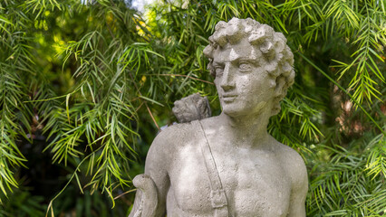 A statue of a person in a tropical garden setting