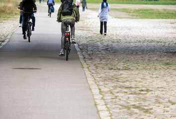 Konzept Nahmobilität im Alltag: Blick auf einen ausgebauten Radweg und Gehweg mit mehreren Radfahrern und Fußgängern – viel Copy Space im Vordergrund