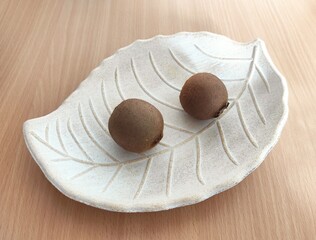 Kiwi and shiny brown chestnuts on the table