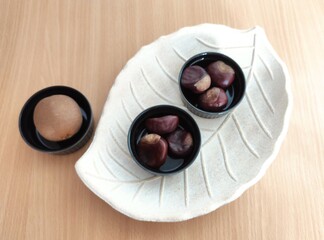 Kiwi and shiny brown chestnuts on the table