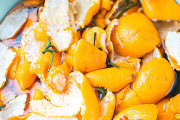 Tangerine zest or peels soaked in water for making candied fruit. Close-up. Background.