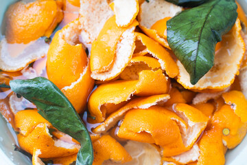 Tangerine zest or peels soaked in water for making candied fruit. Close-up. Background.