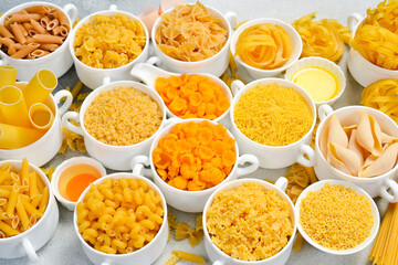 Pasta background. Set of uncooked macaroni in white ceramic bowls. Wide selection.